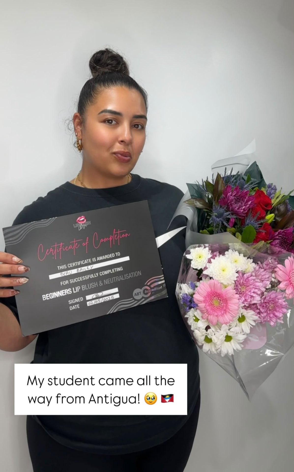 Student with her certificate and two bouquets